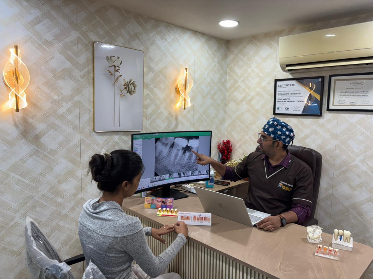 Dr. Shashank reviewing a dental X-ray with a patient at the consultation desk