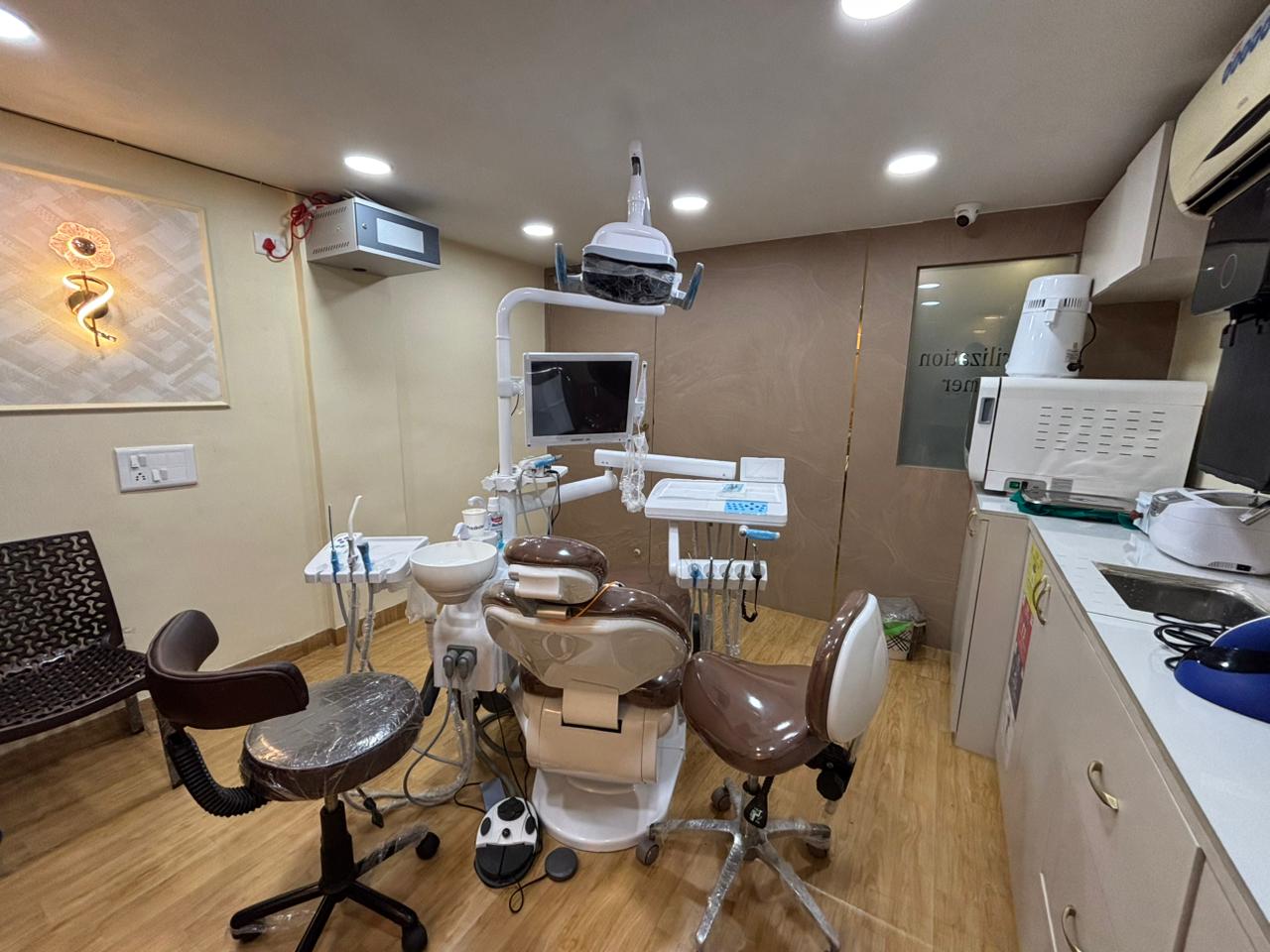 The main dental treatment chair with overhead light and chairside monitor